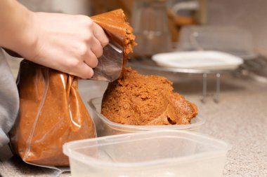 Bir kadının elleri miso 'yu bir kabın içinde saklıyor.