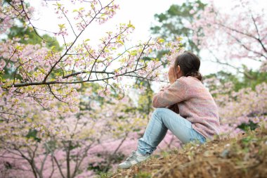 Asyalı küçük kız bahçede bahar tatilinin tadını çıkar..