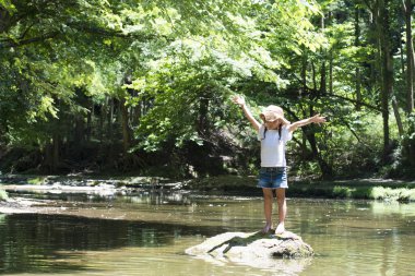 Dağ deresinde oynayan mutlu küçük kız