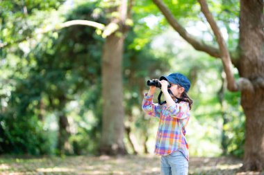Ormanda dürbünlü genç Asyalı kız
