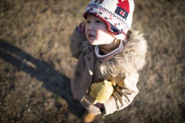 Parkta oyuncak ayıyla oynayan bir kız.
