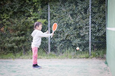 Tenis oynayan mutlu küçük kız