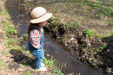 Güneşli bir bahar gününde baharda yürüyen bir kız.