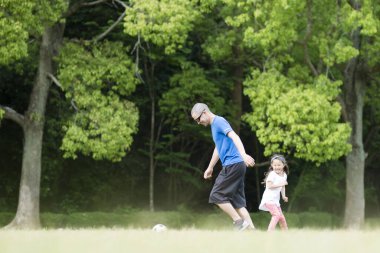 Baba ve kızı futbol topuyla oynuyorlar.