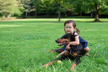 Parkta köpeği olan Asyalı genç bir kız.