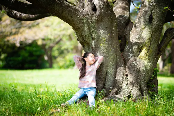 Parktaki ağaçların orada küçük sevimli Asyalı kız.