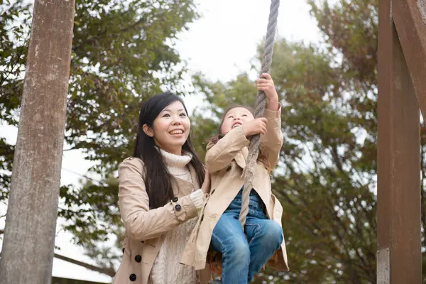 Anne ve kızı parkta oynuyorlar.