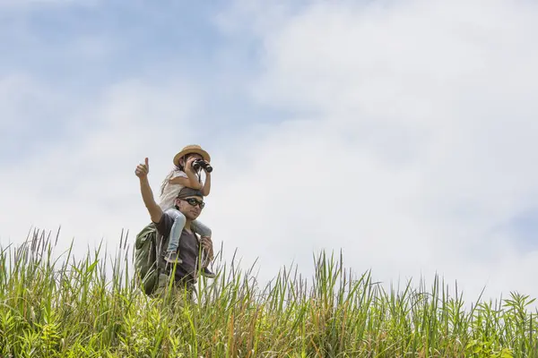 Baba ve kızı çayırda oynuyorlar.