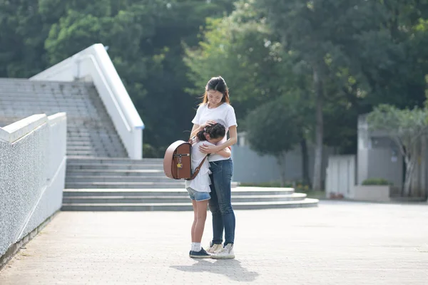 Güzel bir kadın bir kıza sarılıyor.