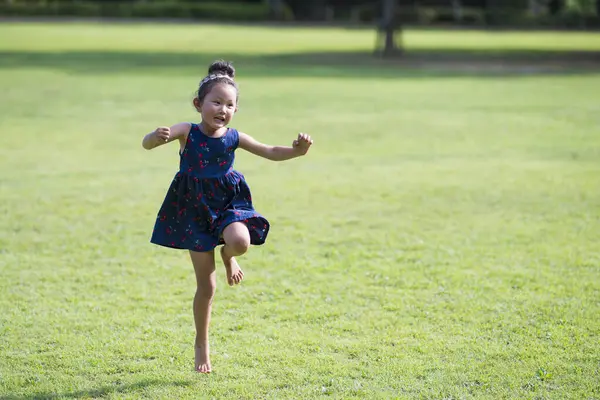 Asyalı kız çimlerin üzerinde zıplıyor