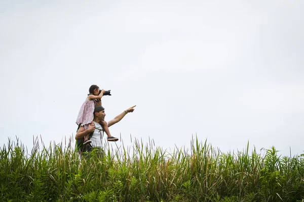 Baba ve kızı çayırda oynuyorlar.
