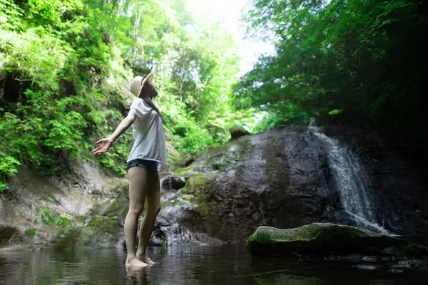 Dağın deresinde dinlenen bir kadın.