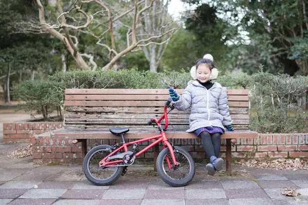 Parkta bisikleti olan sevimli Asyalı kız.