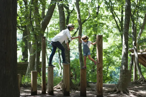 Anne ve kızı parkta oynuyorlar.
