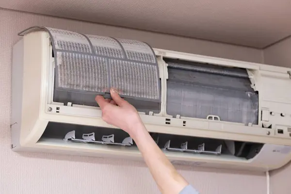 Woman's hands cleaning the air conditioner