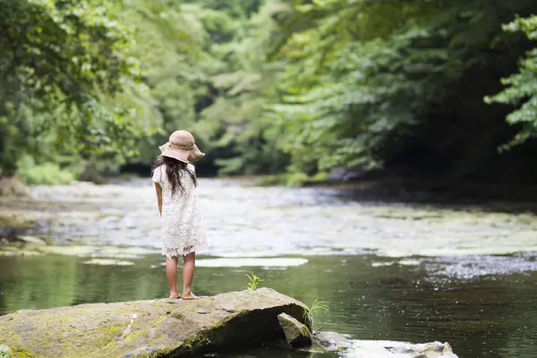 Nehir kıyısında beyaz şapkalı bir kız