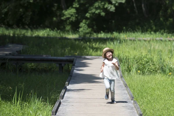 Parkta yürüyen küçük Asyalı kız.