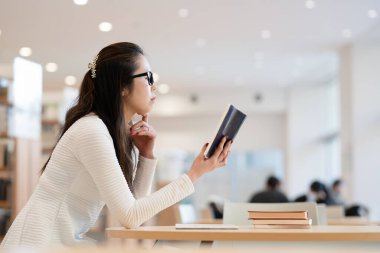 genç kadın öğrenci okuma kitabı Kitaplığı'nda 