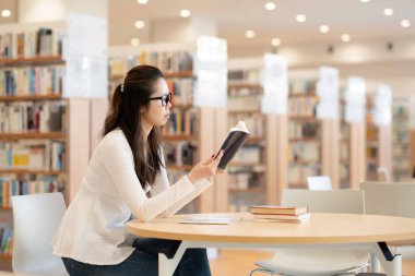 genç kadın öğrenci okuma kitabı Kitaplığı'nda 