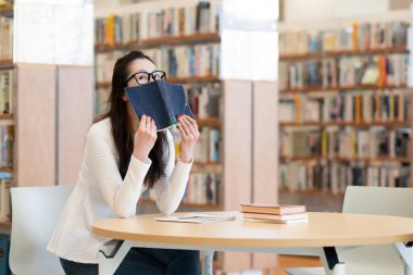 genç kadın öğrenci okuma kitabı Kitaplığı'nda 