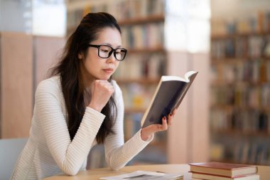 genç kadın öğrenci okuma kitabı Kitaplığı'nda 