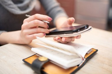 Deftere yazan bir kadının elleri.