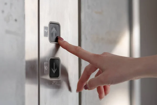 woman pressing button of  lift  in modern hotel, closeup