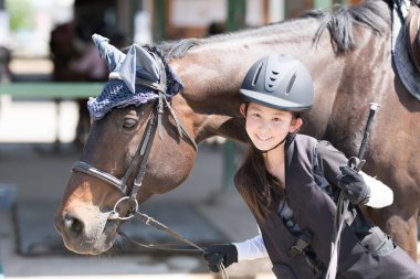 Kız ata binmeye hazırlanıyor.