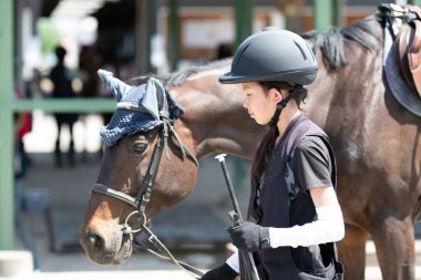 Kız ata binmeye hazırlanıyor.