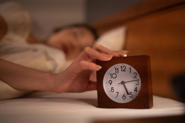 Sabahın köründe alarmını kapatan bir kadın.