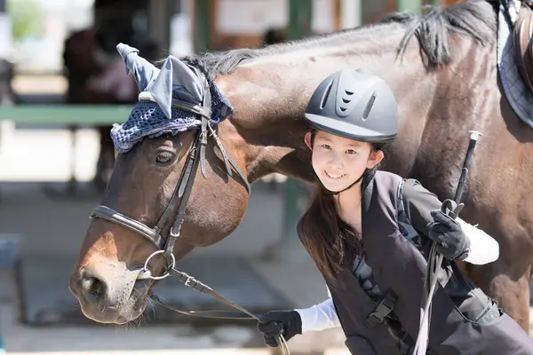Kız ata binmeye hazırlanıyor.