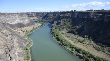 Nehir vadide. Sakin dağ nehri. Volkanik bir geçitte nehir. Amerika 'nın doğası. Idaho 'nun doğası. Twin Falls kasabası. Volkanik kayalar. Nehrin kayalık kıyıları. Kuzey Amerika doğası. Doğa manzarası. Dağ nehri manzarası. Kanyon.
