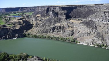 Nehir vadide. Sakin dağ nehri. Volkanik bir geçitte nehir. Amerika 'nın doğası. Idaho 'nun doğası. Twin Falls kasabası. Volkanik kayalar. Nehrin kayalık kıyıları. Kuzey Amerika doğası. Doğa manzarası. Dağ nehri manzarası. Kanyon.