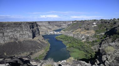 Nehir vadide. Sakin dağ nehri. Volkanik bir geçitte nehir. Amerika 'nın doğası. Idaho 'nun doğası. Twin Falls kasabası. Volkanik kayalar. Nehrin kayalık kıyıları. Kuzey Amerika doğası. Doğa manzarası. Dağ nehri manzarası. Kanyon.