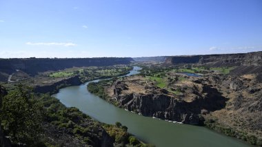 Nehir vadide. Sakin dağ nehri. Volkanik bir geçitte nehir. Amerika 'nın doğası. Idaho 'nun doğası. Twin Falls kasabası. Volkanik kayalar. Nehrin kayalık kıyıları. Kuzey Amerika doğası. Doğa manzarası. Dağ nehri manzarası. Kanyon.