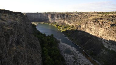 Nehir vadide. Sakin dağ nehri. Volkanik bir geçitte nehir. Amerika 'nın doğası. Idaho 'nun doğası. Twin Falls kasabası. Volkanik kayalar. Nehrin kayalık kıyıları. Kuzey Amerika doğası. Doğa manzarası. Dağ nehri manzarası. Kanyon.