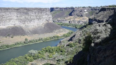 Nehir vadide. Sakin dağ nehri. Volkanik bir geçitte nehir. Amerika 'nın doğası. Idaho 'nun doğası. Twin Falls kasabası. Volkanik kayalar. Nehrin kayalık kıyıları. Kuzey Amerika doğası. Doğa manzarası. Dağ nehri manzarası. Kanyon.