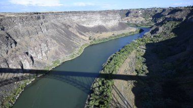 Nehir vadide. Sakin dağ nehri. Volkanik bir geçitte nehir. Amerika 'nın doğası. Idaho 'nun doğası. Twin Falls kasabası. Volkanik kayalar. Nehrin kayalık kıyıları. Kuzey Amerika doğası. Doğa manzarası. Dağ nehri manzarası. Kanyon.