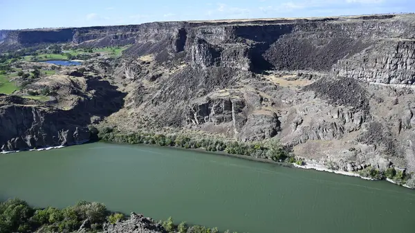 Nehir vadide. Sakin dağ nehri. Volkanik bir geçitte nehir. Amerika 'nın doğası. Idaho 'nun doğası. Twin Falls kasabası. Volkanik kayalar. Nehrin kayalık kıyıları. Kuzey Amerika doğası. Doğa manzarası. Dağ nehri manzarası. Kanyon.