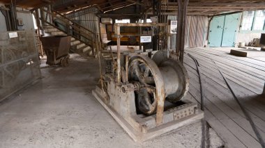 Beyaz arka planda eski paslı ahşap tekerlekler. Altın madeni müzesi