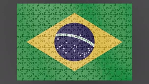 表面に落ちるブラジルの旗のアニメーションは アルファチャンネルと影を持つパズルから組み立てられました 風は散らばったブラジルの作品をフレームから吹き飛ばします — ストック動画