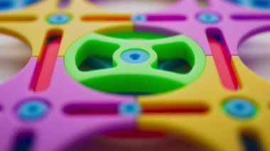 Renkli çocuklardan oluşan bir grup plastik geometrik şeklin animasyonu. Döngülü hareket. Yakın plan. Odaklanmayın