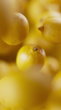 Bir grup limonun animasyonu. Birçok limon uzayda arka planda yavaşça döner. Dikey kompozisyon. Defoktus. Yakın plan..