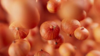 Bir grup balkabağı animasyonu. Birçok balkabağı uzayda arka planda yavaşça döner. Yatay bileşim. Defoktus. Yakın plan..