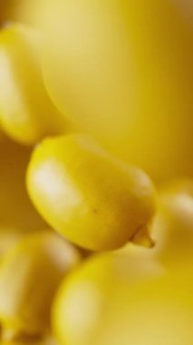 Bir grup limonun animasyonu. Birçok limon uzayda arka planda yavaşça döner. Dikey kompozisyon. Defoktus. Yakın plan. Döngü.