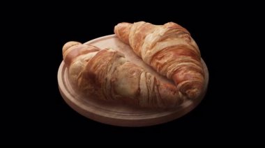 Tahta bir tahtanın üzerinde duran iki kruvasan kompozisyonu etrafında döngü çiziyor. Döngü hareketi. Alfa Kanalı. Yakın plan..