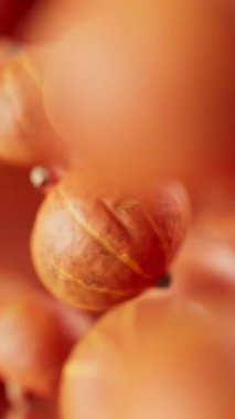 Looping animation of a group of pumpkins. Many pumpkins slowly rotate in the background in space. Vertical composition. Defocus. Close-up. Cycle.