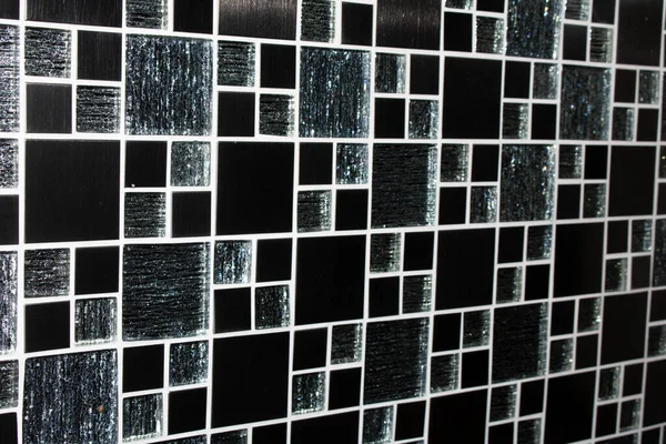A Black and white mosaic tiles wall texture. Abstract background and texture for design.