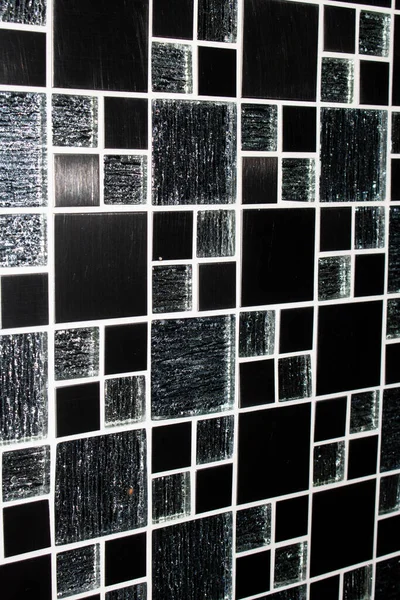 A Black and white mosaic tiles wall texture. Abstract background and texture for design.