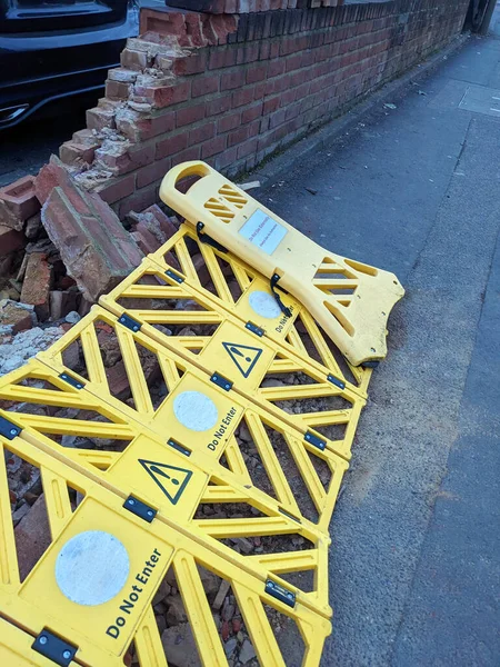 A Broken Wall in A Carpark Been Hit by a Car  With Warning Barrier Around the Fallen Bricks